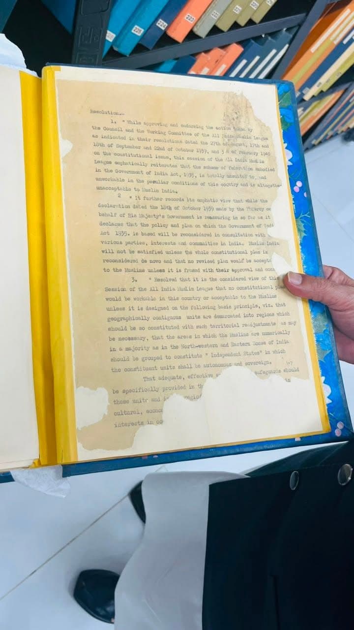 A typed page of the 1940 All India Muslim League resolution held in a protective folder