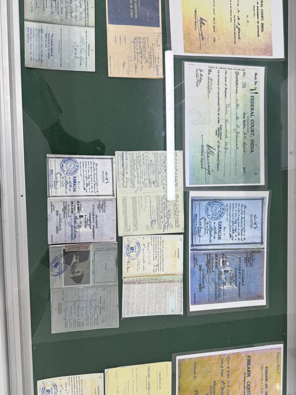 A showcase of passports, a Federal Court of India receipt and firearms certificates