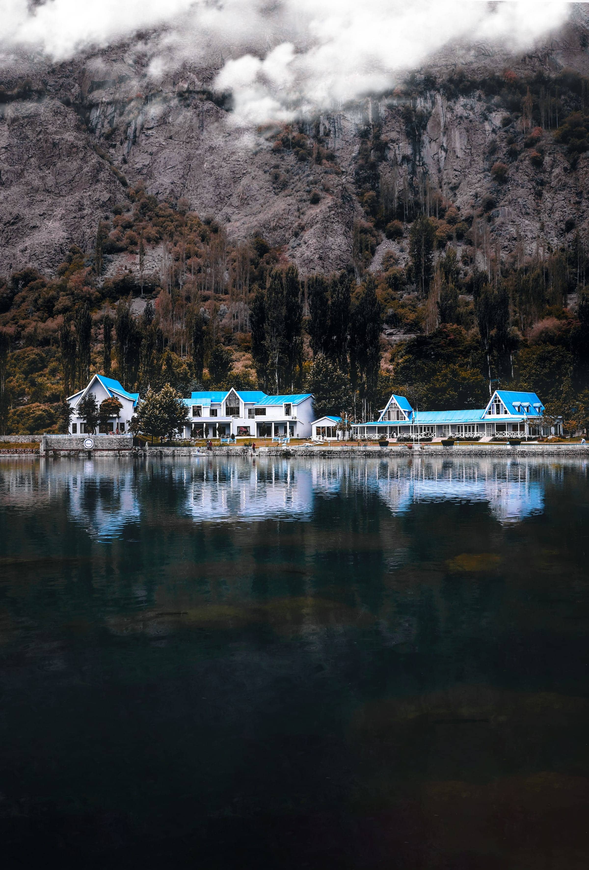 Lakeside lodges reflected in a still lake near Skardu
